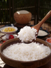 Fresh Cooked White Long Grain Rice on Wooden Spoon from Traditional Clay Bowl Asian Kitchen