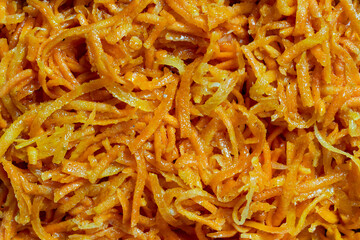 Vibrant texture of finely shredded orange carrots, filling the entire image, closeup, top view