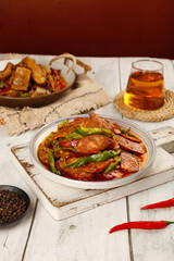 Sichuan Pork Sausage Stir-Fry with Peppers - Traditional Chinese Cuisine on Rustic Wooden Board