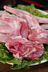 Raw Rabbit Meat Cuts Fresh Foreleg Pieces for Sichuan Cooking on Lettuce Leaves