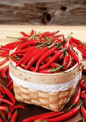 Fresh Red Hot Chili Peppers in Rustic Woven Basket on Wood Background