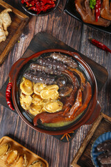 Asian Clay Pot Soup with Dumplings and Mushrooms on Wooden Table