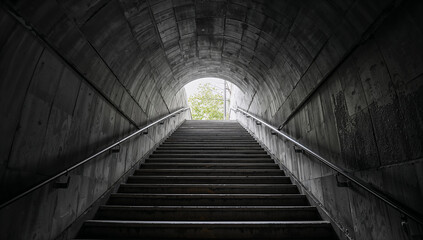 Fototapeta premium Concrete tunnel staircase leading to bright outdoor light