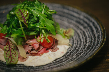 Roast beef carpaccio plate with mixed greens