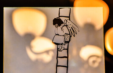 The little angel is sitting on the ladder.