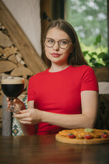 Young woman enjoying beer and snack in cafe