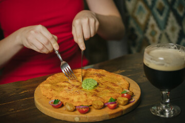 Woman cutting a flatbread dish with beer