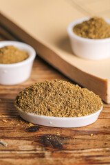 Ground Cumin Powder and Spices in White Bowls on Rustic Wood Background for BBQ Cooking