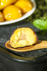 Roasted Chestnut Cut Open Showing Golden Kernel and Flesh on Wooden Spoon