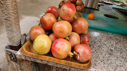 A pile of pomegranates on a café counter, intended for making juice