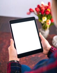 Tablet held by person, white screen, flowers