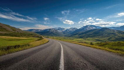 Naklejka premium Scenic highway winding through a valley, mountains in the distance