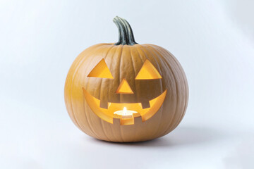 Fototapeta premium Carved jack-o’-lantern pumpkin with glowing candlelight inside, photographed on a light grey background, perfect for Halloween theme and design