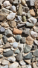 A natural stone wall pattern on an exterior garden wall in the Mediterranean region, for design backgrounds