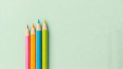 Vibrant colored pencils lined up on a soft green background provide a creative and modern aesthetic, great for back to school promotions