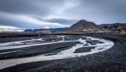 Cinematic geomorphic photo of an alluvial fan under slate overcast, braided pale channels etched across dark gravel for refined contrast.