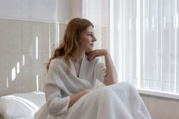 Health and beauty concept: woman in robe receiving medical blood draw for cosmetic treatment