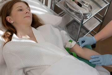 Hospital lab technician performing precise venipuncture for diagnostic purposes