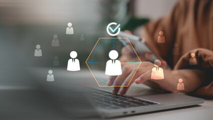 Hand using laptop and smartphone with virtual human resource icons, representing digital recruitment, talent selection, HR technology, candidate screening, and employee hiring solutions.