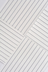 A close-up photograph of four rectangular pieces of white plastic twist ties with wire cores, arranged to form a crisscross pattern