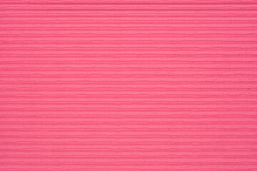 Fototapeta premium A full-frame, detailed close-up of a pink textured cardboard surface with fine horizontal lines