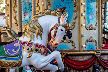 Detalle de caballos blancos en un carrusel, rotonda o tiovivo de estilo retro