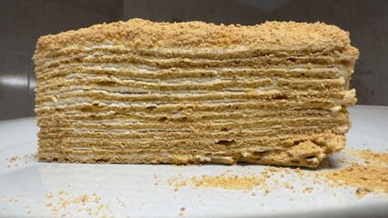 Slice of honey Medovik layered cake with cream filling, close-up