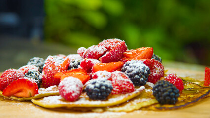 Delicious Stack of Golden Pancakes with Fresh Mixed Berries, Powdered Sugar, and Syrup