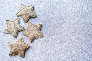 Top view of star-shaped Christmas ornaments on a glittery background