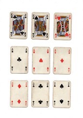 Three different hands of grubby vintage playing cards isolated on a white background.