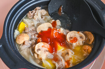 煮込んだ肉と野菜にケチャップを加える