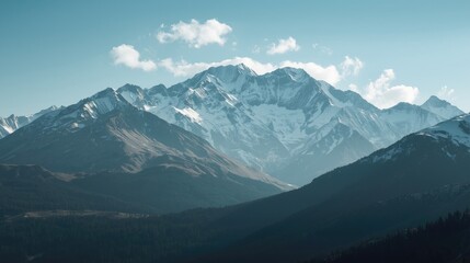 Fototapeta premium Majestic mountain range rises against a serene, light-blue sky, showcasing snow-capped peaks and layered slopes.