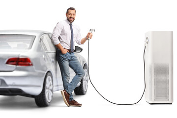 Man leaning on electric car and holding a charger