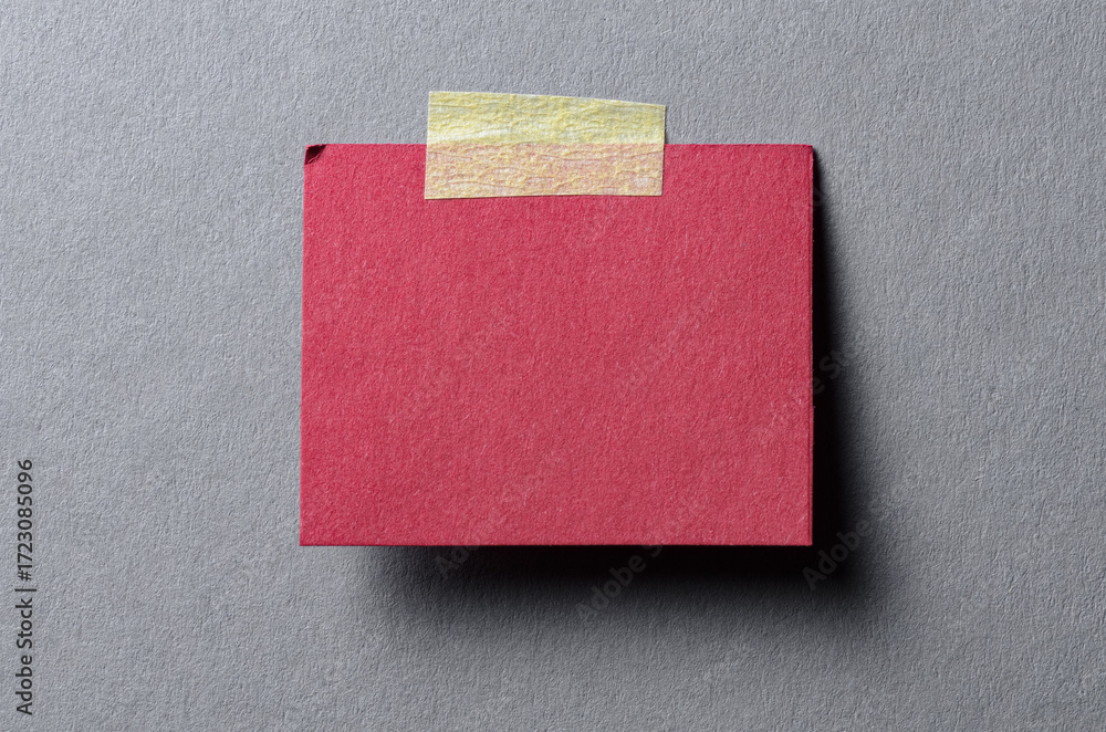 Poster piece of blank red paper note with adhesive sticky tape and shadow on gray background