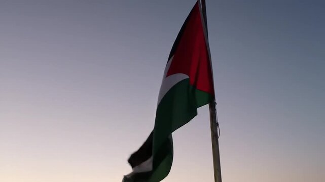 The national flag of the Hashemite Kingdom of Jordan waving majestically against a serene twilight sky, symbolizing pride and sovereignty