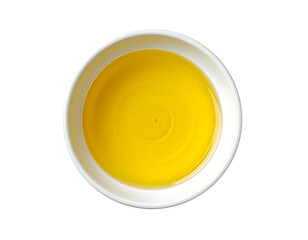 Overhead view of a small, white bowl filled with a vibrant yellow liquid, showing subtle concentric circles on its surface