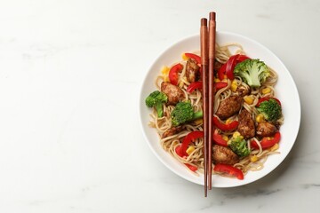Delicious noodles with meat, vegetables and chopsticks on white marble table, top view. Space for text