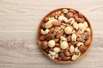 Mix of different nuts on wooden table, top view. Space for text