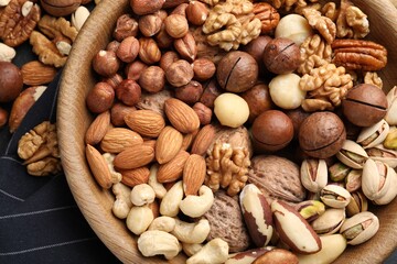 Mix of different nuts in bowl on table, top view