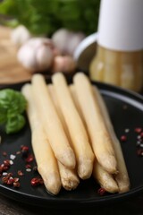 Pickled asparagus and spices on wooden table, closeup