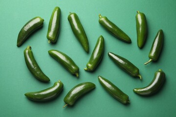 Ripe jalapeno peppers on green background, flat lay