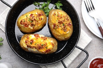 Tasty stuffed baked potatoes served on grey table, flat lay