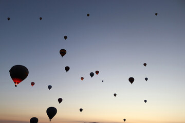 Flying hot air balloons rise in sunrise Cappadocia.