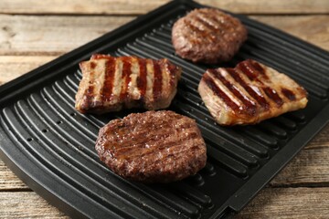 Delicious grilled beef meat on wooden table, closeup