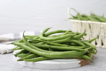 Fresh green bean pods on grey table, closeup