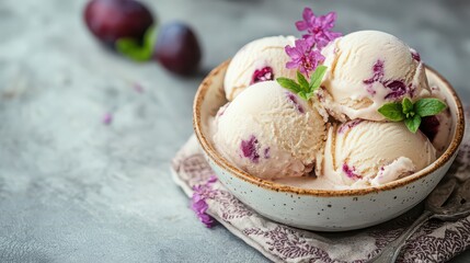 Fototapeta premium Delicious plum ice cream scoops in a bowl with fresh flowers and plums nearby