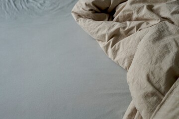 There is a bed that has a cozy blanket and a soft pillow resting on it bedsheet messy unmade do bed...