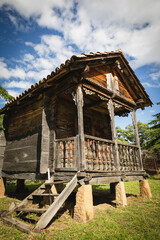 Traditional wooden hut on stilts in Georgia, showcasing ethnic architecture and rustic charm under a dramatic summer sky