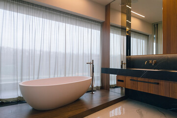 A beautifully spacious modern bathroom featuring a luxurious freestanding bathtub paired with stylish wooden cabinetry, creating comfort and elegance