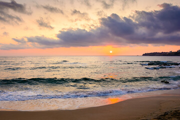 sea beach landscape on autumn sunrise. calm wave on sand shore. dramatic clouds above horizon. velvet season vacation in bulgaria